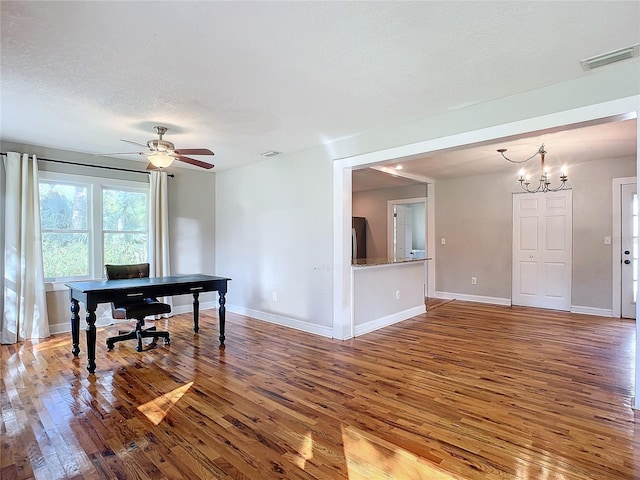 office area featuring a textured ceiling, hardwood / wood-style flooring, and ceiling fan with notable chandelier