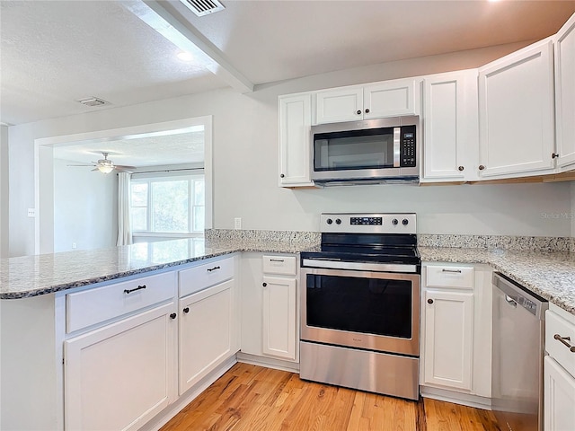 kitchen featuring kitchen peninsula, stainless steel appliances, white cabinetry, a textured ceiling, and light hardwood / wood-style floors