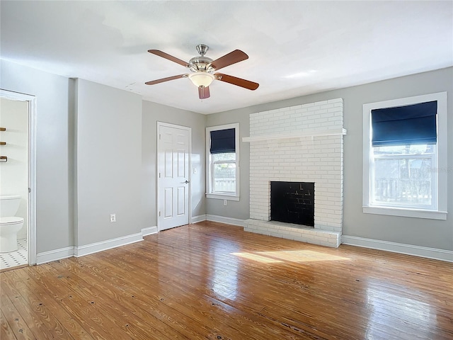 unfurnished living room featuring hardwood / wood-style floors, a fireplace, and ceiling fan