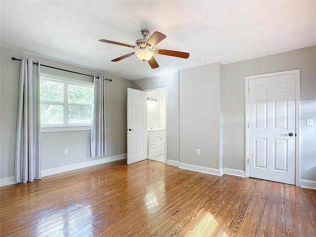 unfurnished bedroom featuring ceiling fan, hardwood / wood-style flooring, and ensuite bath