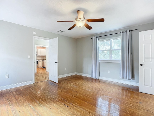 spare room featuring light hardwood / wood-style floors and ceiling fan