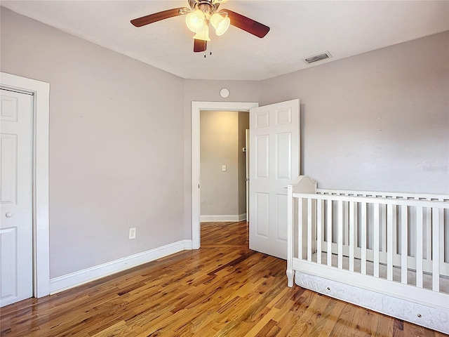 unfurnished bedroom featuring a closet, wood-type flooring, and ceiling fan