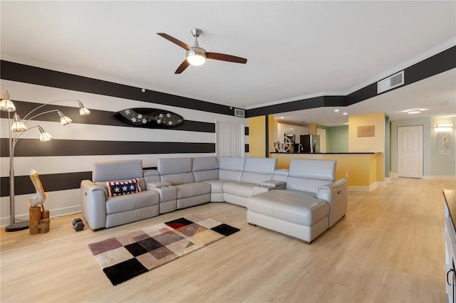 living room with light wood-type flooring, ceiling fan, and crown molding