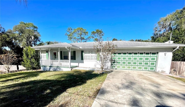 ranch-style home featuring covered porch, a front yard, and a garage