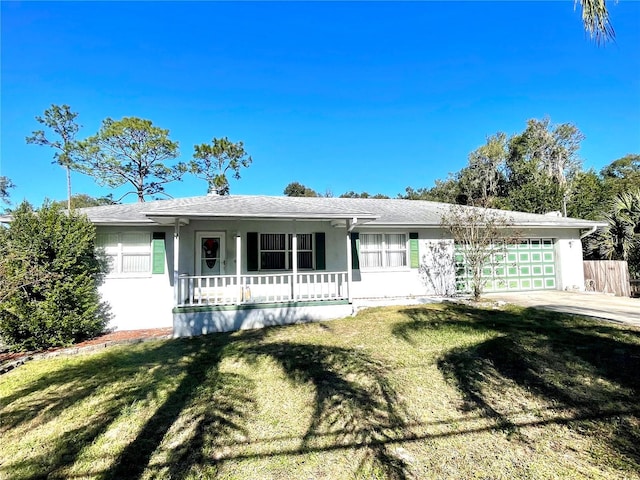 ranch-style house featuring a front lawn, covered porch, and a garage