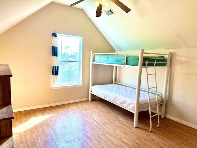 bedroom featuring lofted ceiling, baseboards, visible vents, and wood finished floors