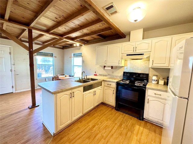 kitchen with black electric range oven, freestanding refrigerator, a sink, a peninsula, and under cabinet range hood