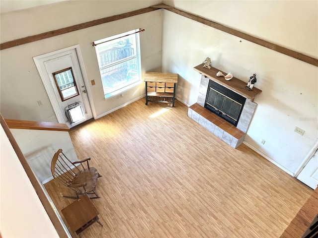 unfurnished living room featuring light wood-type flooring, a fireplace, and baseboards