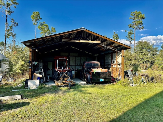 view of pole building featuring driveway and a lawn