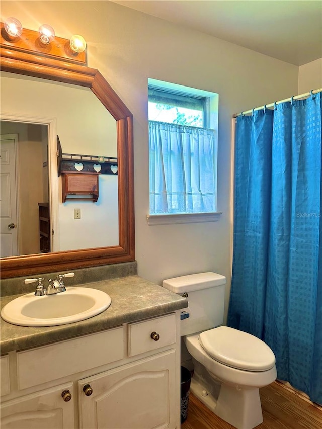 full bathroom featuring curtained shower, vanity, toilet, and wood finished floors