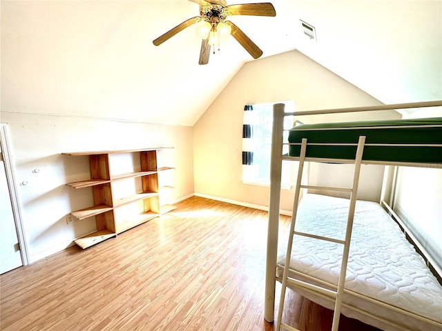 unfurnished bedroom featuring lofted ceiling, wood finished floors, a ceiling fan, visible vents, and baseboards