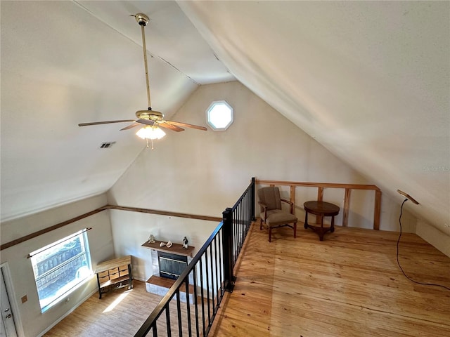 additional living space with light wood-style floors, lofted ceiling, visible vents, and ceiling fan