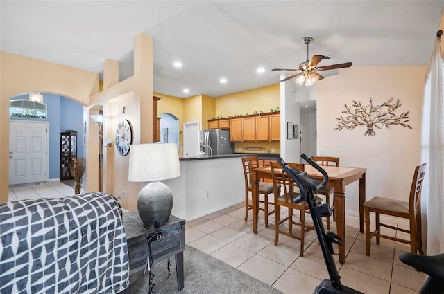 dining room with lofted ceiling, light tile patterned flooring, and ceiling fan