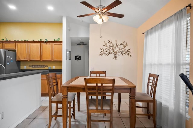 dining area with light tile patterned floors, lofted ceiling, and ceiling fan