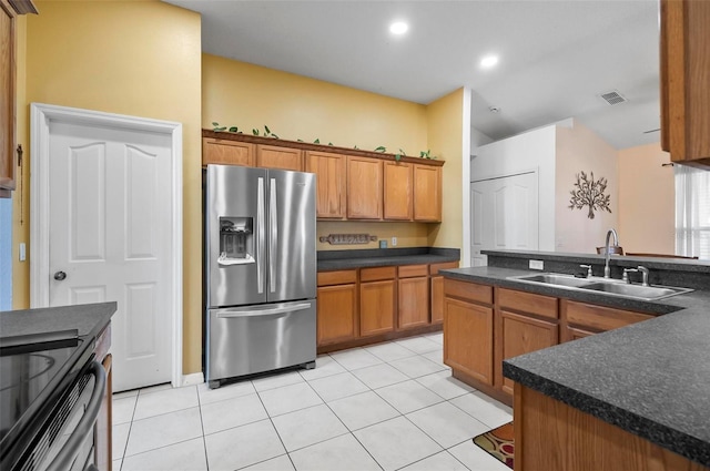 kitchen with sink, stainless steel refrigerator with ice dispenser, and light tile patterned floors