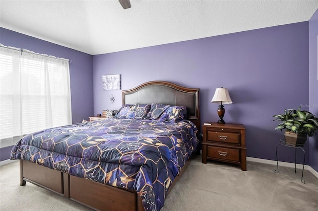 carpeted bedroom featuring a textured ceiling and ceiling fan