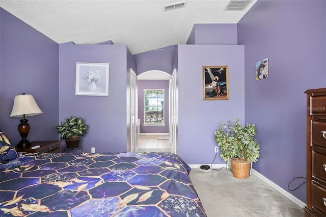 bedroom featuring lofted ceiling, carpet floors, and a textured ceiling