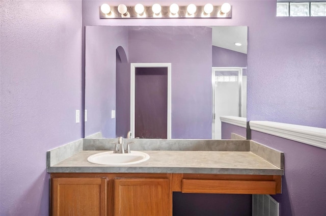 bathroom featuring vanity and lofted ceiling