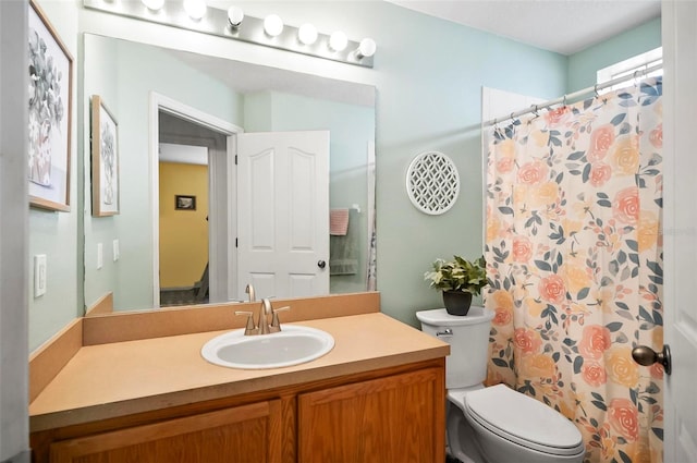 bathroom with toilet, vanity, and a shower with shower curtain