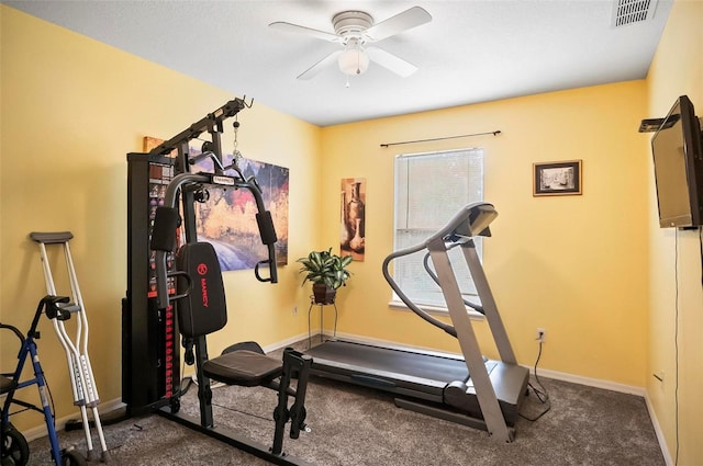 exercise area with ceiling fan and dark colored carpet