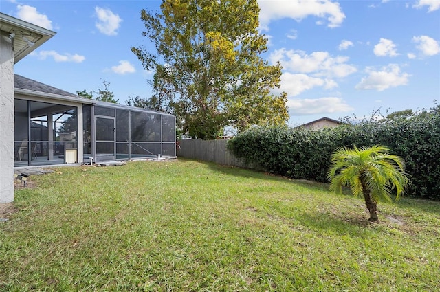 view of yard featuring glass enclosure and a sunroom