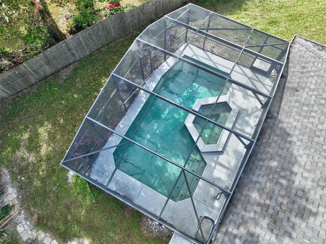 view of pool featuring an in ground hot tub, a patio area, and glass enclosure