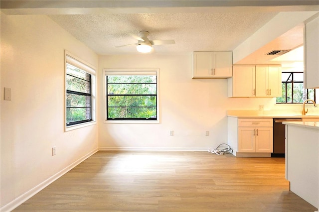 kitchen with light hardwood / wood-style floors, white cabinets, sink, and ceiling fan