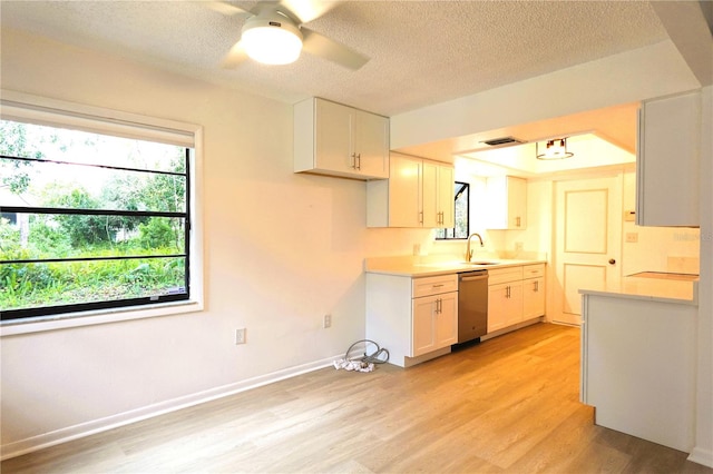 kitchen with dishwasher, a textured ceiling, ceiling fan, light hardwood / wood-style floors, and white cabinets