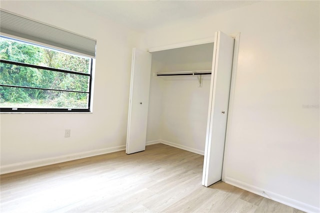 unfurnished bedroom with light hardwood / wood-style floors and a closet