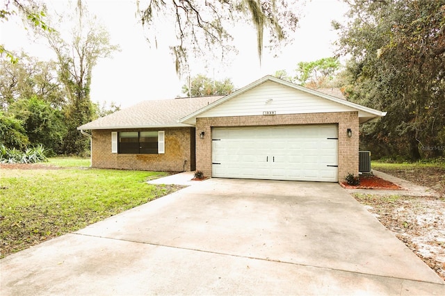 ranch-style house with central air condition unit, a front yard, and a garage