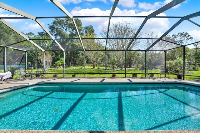 view of swimming pool with glass enclosure, a patio area, and a yard