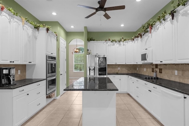 kitchen featuring white cabinets, appliances with stainless steel finishes, light tile patterned flooring, and a center island