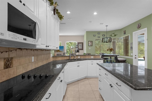 kitchen featuring white cabinets, a notable chandelier, sink, white appliances, and decorative light fixtures