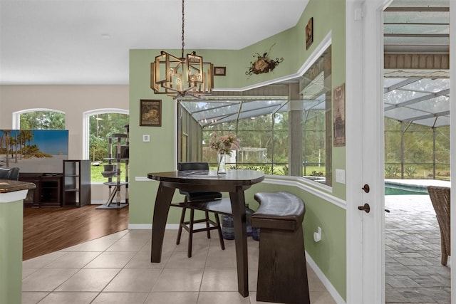 dining space with light hardwood / wood-style flooring and an inviting chandelier