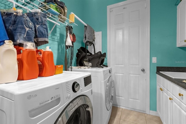 laundry area with cabinets, light tile patterned floors, and washer and clothes dryer