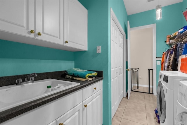 laundry room with cabinets, light tile patterned floors, washer and clothes dryer, and sink