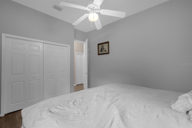 bedroom with ceiling fan, a closet, and dark hardwood / wood-style flooring