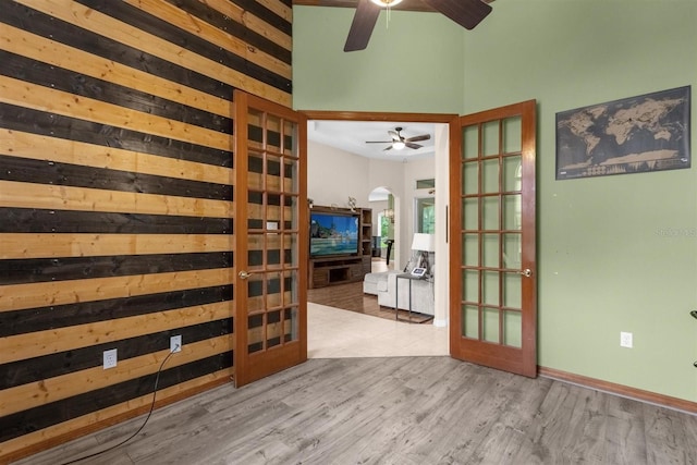 interior space with a towering ceiling, french doors, and light hardwood / wood-style flooring