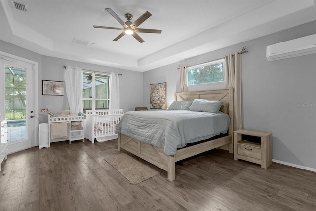 bedroom with access to exterior, multiple windows, ceiling fan, and dark hardwood / wood-style floors