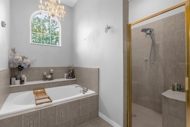 bathroom featuring plus walk in shower, an inviting chandelier, and tile patterned floors