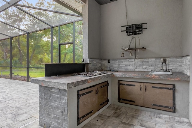 view of patio featuring area for grilling, glass enclosure, and sink