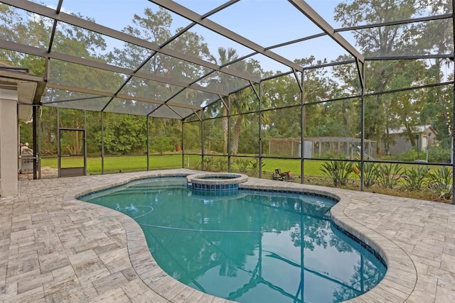 view of pool featuring glass enclosure, a patio area, a lawn, and an in ground hot tub