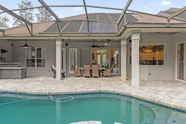 view of pool with exterior kitchen, ceiling fan, a lanai, and a patio area