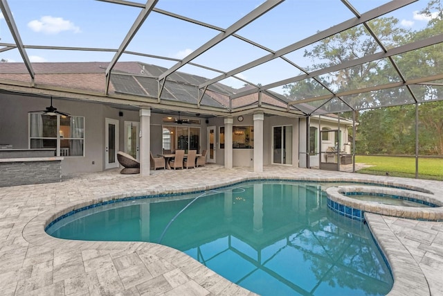 view of swimming pool with a patio area, ceiling fan, glass enclosure, and an in ground hot tub