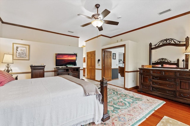 bedroom featuring ornamental molding, vaulted ceiling, ceiling fan, and light wood-type flooring