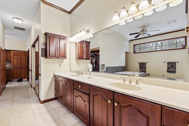 bathroom with tile patterned floors, crown molding, vanity, ceiling fan, and a washtub