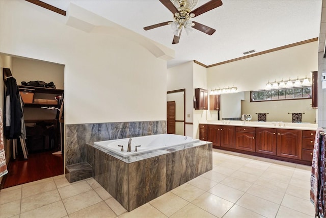 bathroom featuring crown molding, vanity, ceiling fan, tiled bath, and tile patterned flooring