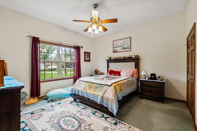 carpeted bedroom featuring ceiling fan and a textured ceiling