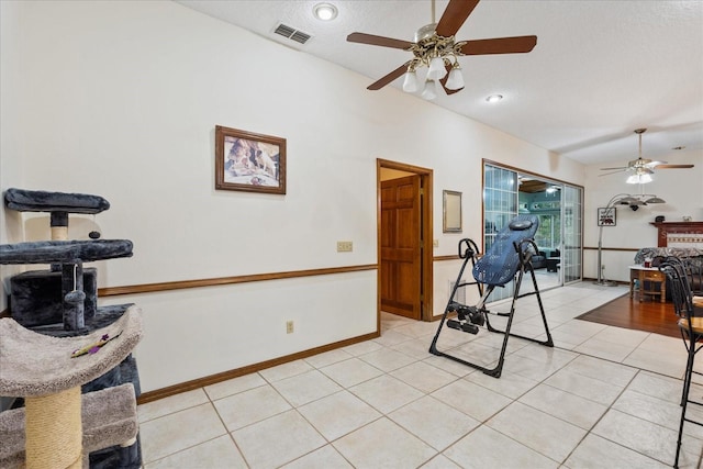 workout area with light tile patterned floors and a textured ceiling