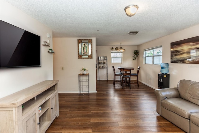 living room with dark wood-type flooring and a textured ceiling